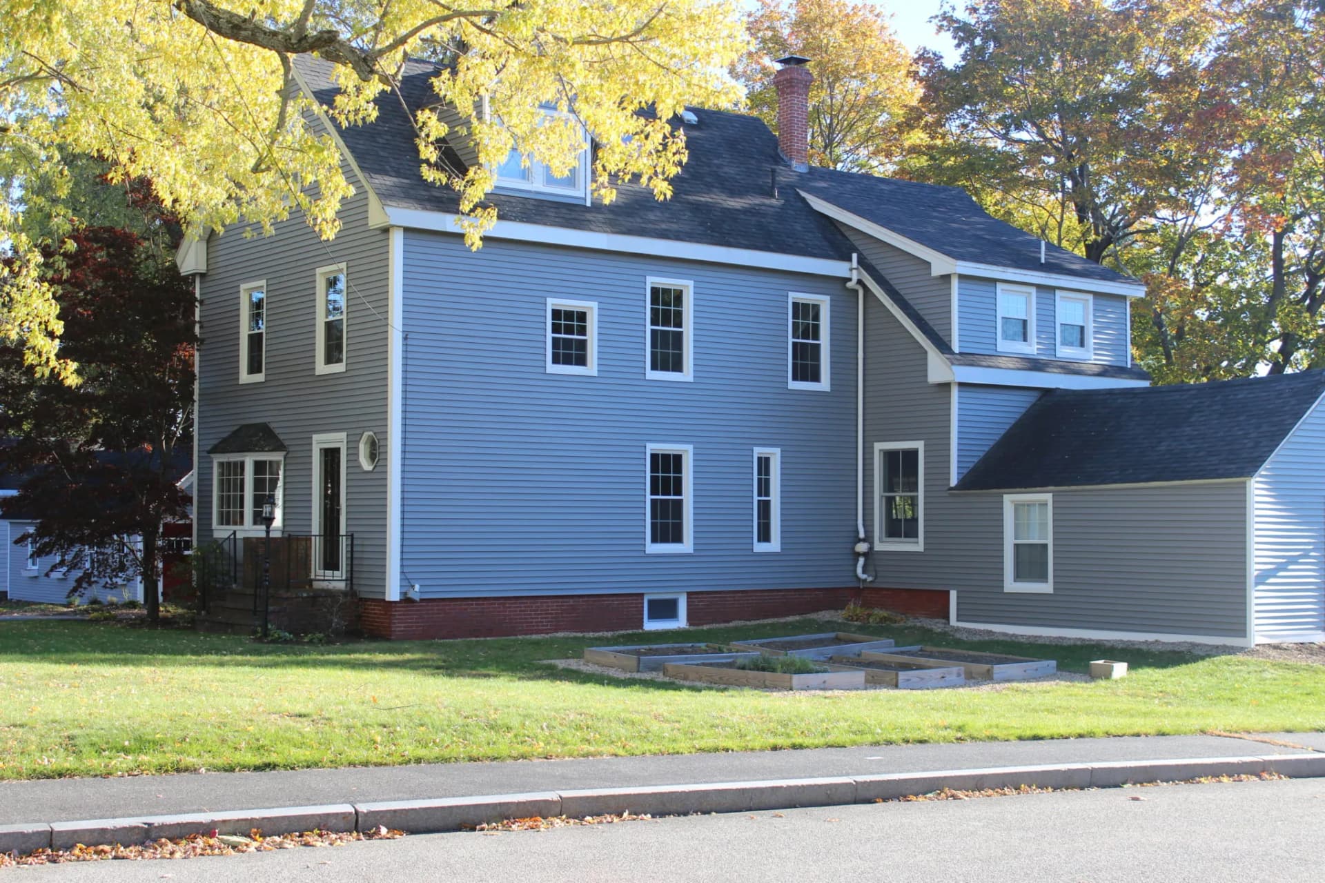 Farmhouse with a rebuilt deck in North Deering, Portland by Cardinal Exteriors