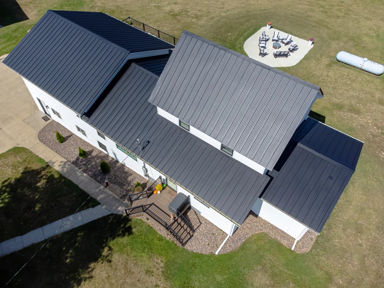 Aerial view of a dark standing-seam metal roof on a modern farmhouse-style home