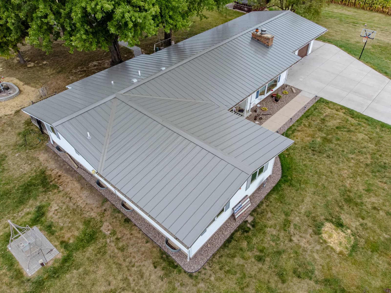 Aerial view of a light gray standing-seam metal roof on a ranch-style home
