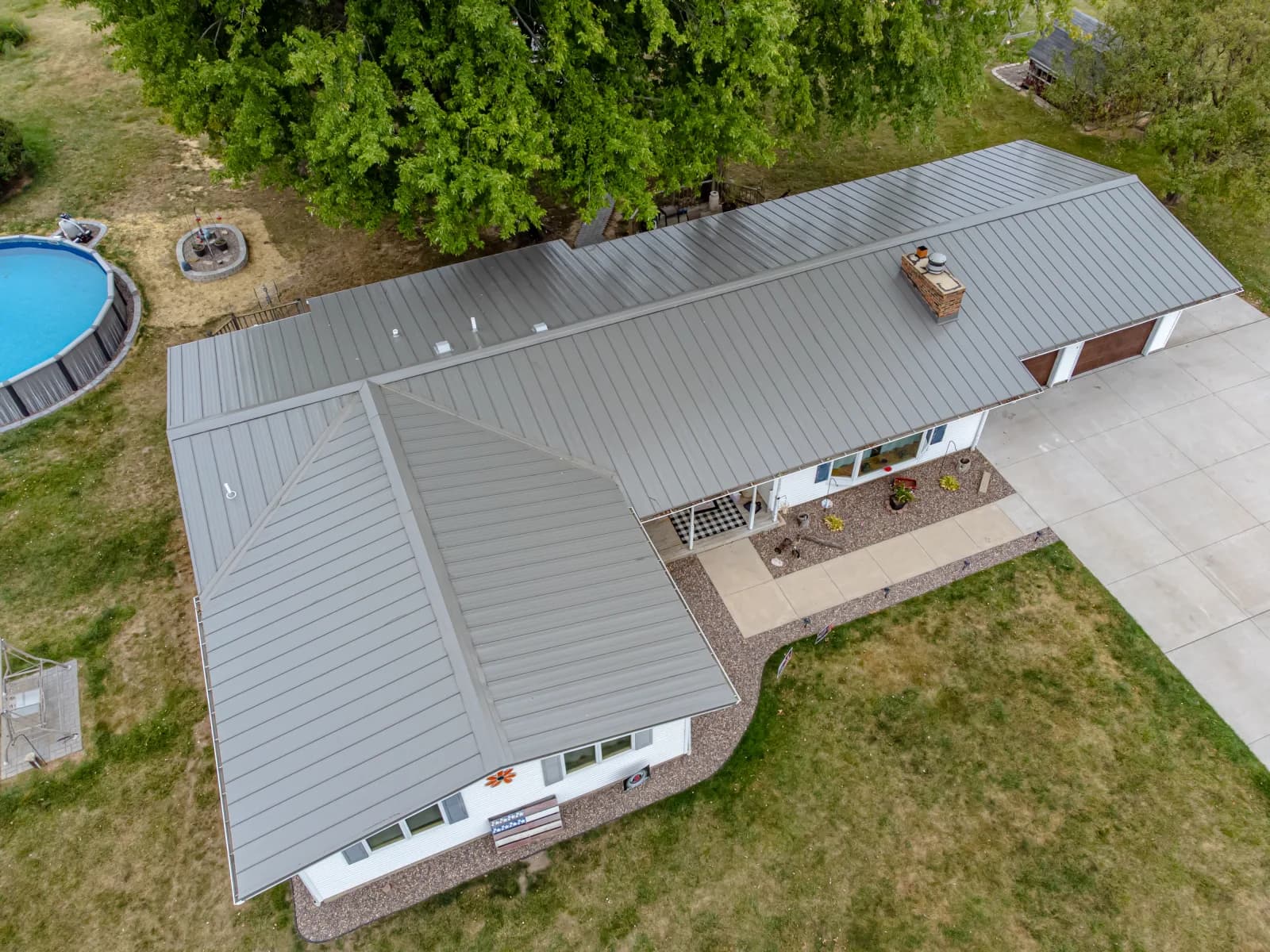 Aerial view of a standing-seam metal roof on a home with an in-ground pool